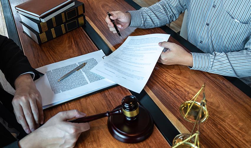 A person holding a pen and an immigration petition at a lawyer's office.