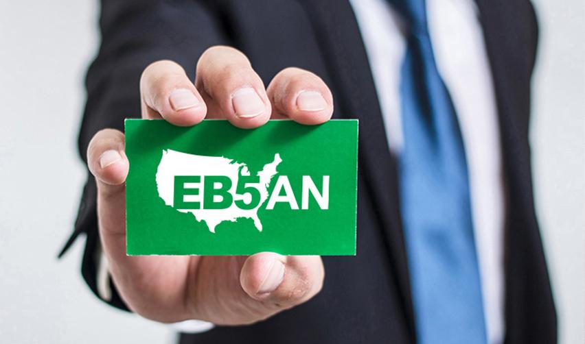 A hand holding a green card