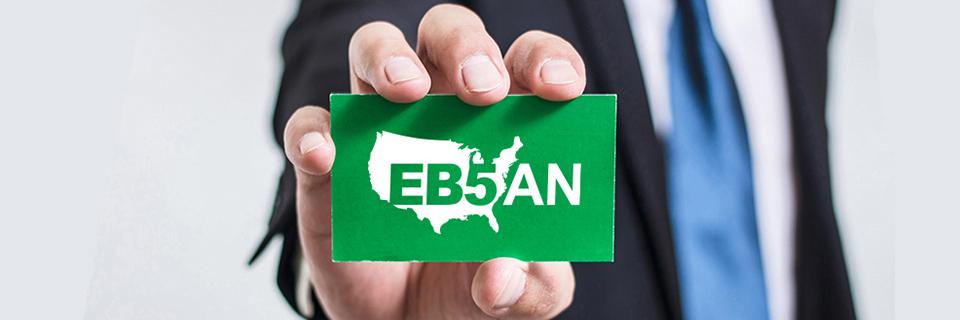 A person holding a green card with the EB5AN logo on it.