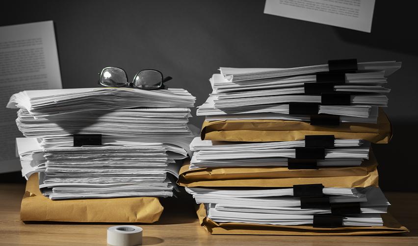 A stack of files and visa application documents on a desk, symbolizing backlog in paperwork.
