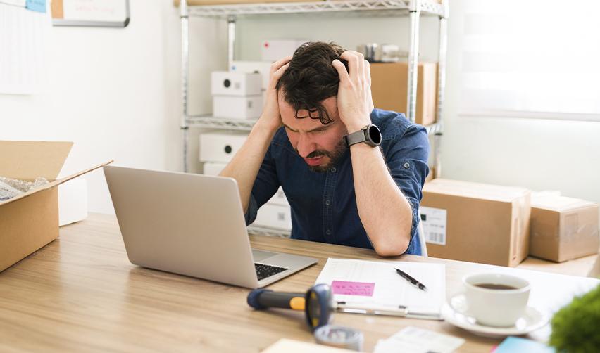 A foreign investor acting distressed in front of a computer.