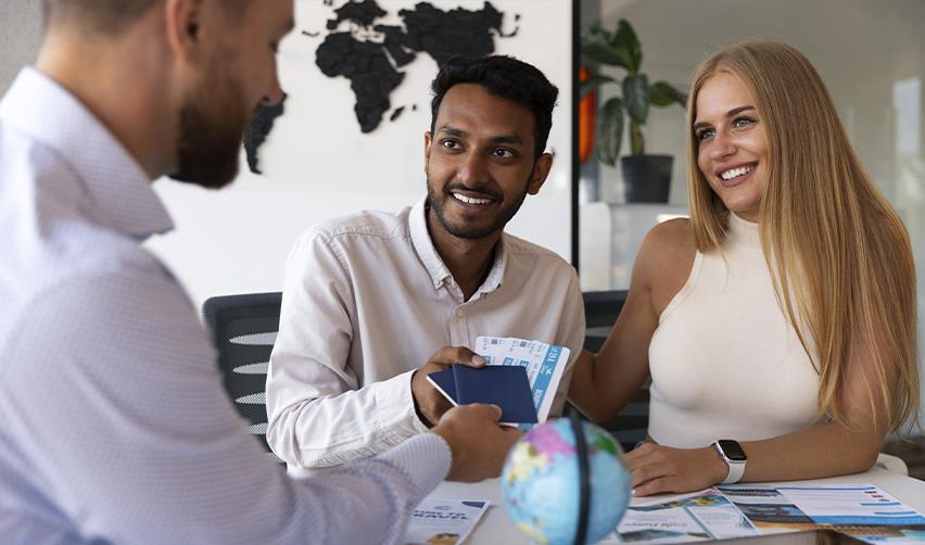 Two immigrant investors receiving their passports from a consular officer.