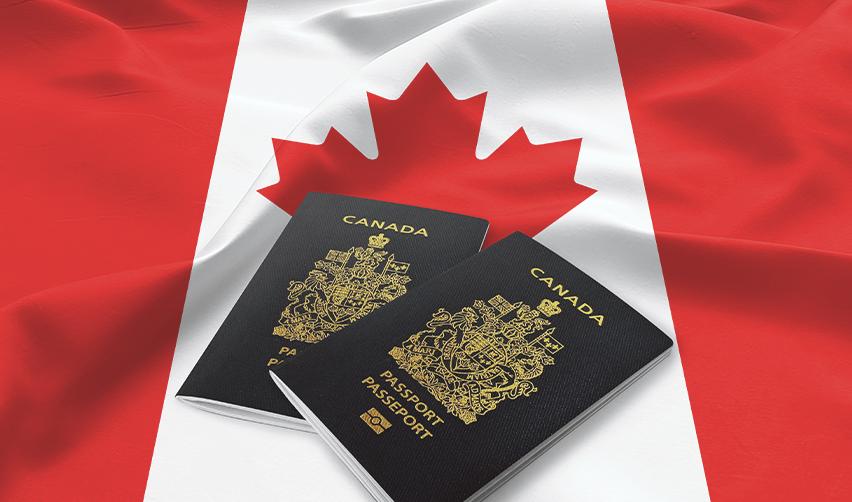 Two Canadian passports on top of a Canadian flag, symbolizing Canada investment visas.