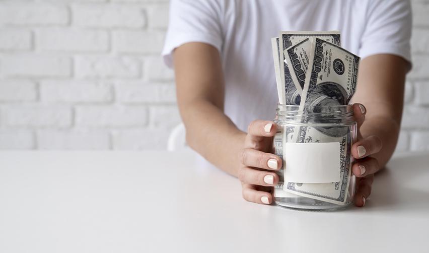 An EB5 investor holding a jar full of money, symbolizing EB5 capital investment repayment.