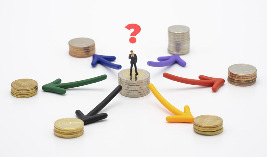 A figurine of an EB5 investor standing on a stack of coins, looking at other capital stack options with a question mark above his head.