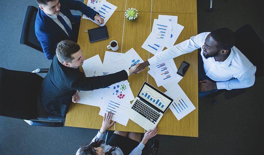 A group of EB5 industry professionals working on some capital investment data at an office.