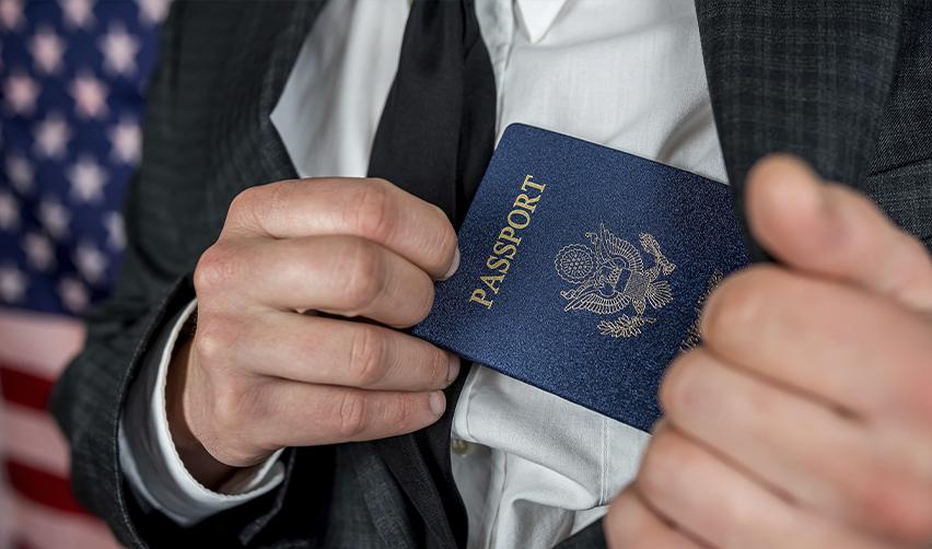 A foreign investor holding a U.S. passport in his jacket pocket after obtaining permanent residency.