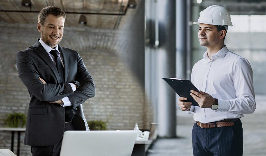 A foreign investor in a suit and an employee in hard hat standing side by side, symbolizing a comparison between U.S. investor visas and work visas.