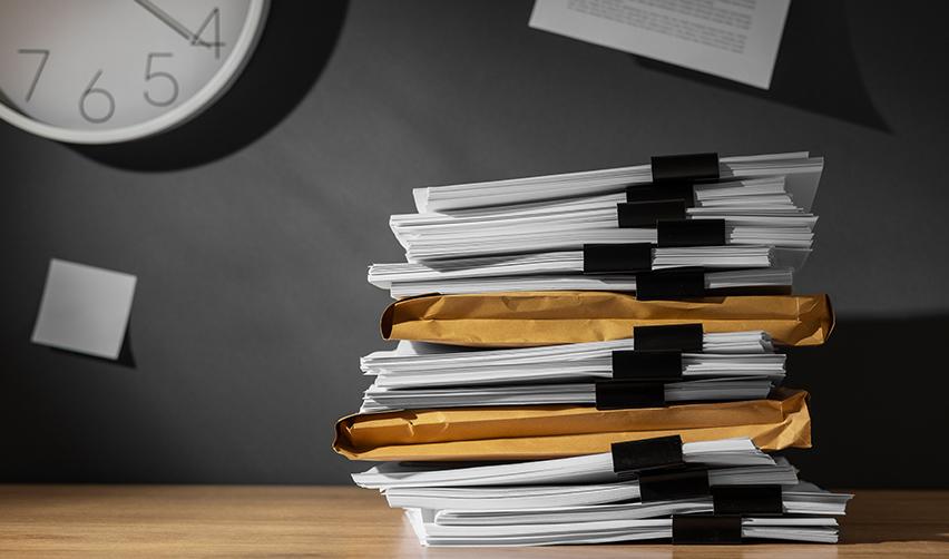 A stack of visa application documents on a desk, symbolizing EB5 backlogs in set-aside categories.