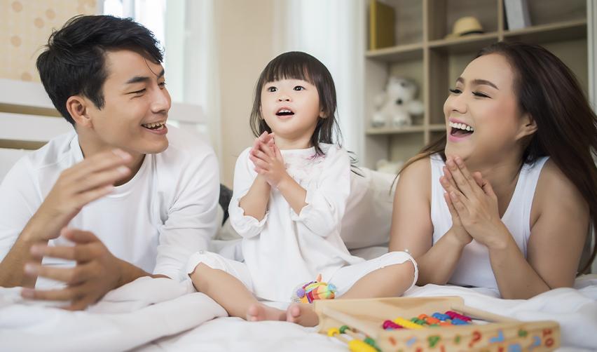 A happy Asian EB5 investor family laughing together. This image conveys the emotional and lifestyle benefits of securing US residency through the EB5 program.