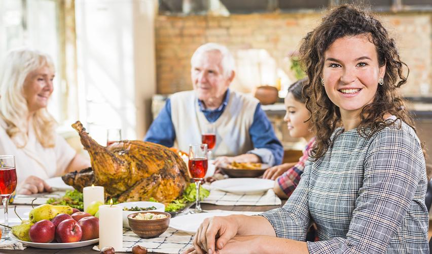 Happy family sharing a Thanksgiving dinner, symbolizing the stability and opportunities provided by an EB5 Green Card.