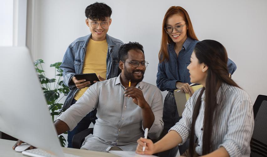 A group of foreign investors gathered in front of a computer after turning their L1 visa to green card through EB5.