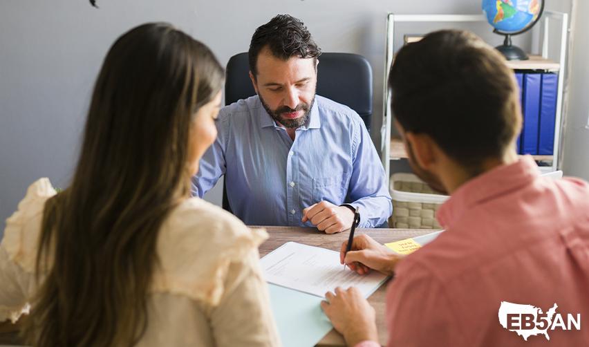 A couple of L1 visa holders turning their L1 visa to green card through an EB5 visa at an uscis service center or regional center office, with the EB5AN logo on the corner.
