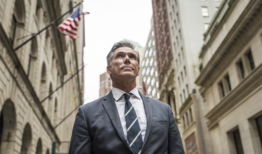 Confident businessman in a suit standing in a US financial district, showcasing the career and financial opportunities available to EB5 visa holders.