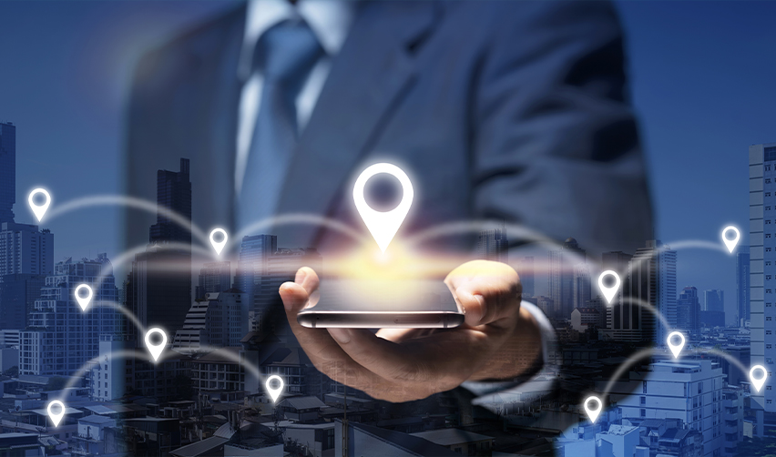 Businessman holding a smartphone with location markers, symbolizing global business expansion opportunities through the EB5 visa program.