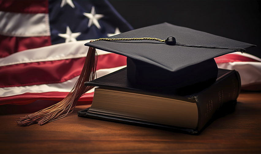 Graduation cap and book in front of the American flag, highlighting educational benefits for EB5 investors and their families.