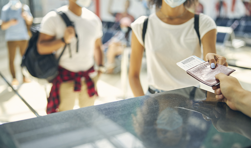 Traveler presenting a passport at an airport counter, representing the concept of second residency.