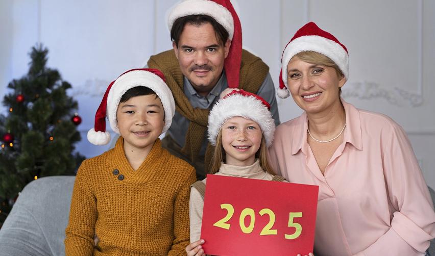 A family holding a festive 2025 sign during holiday celebrations, representing the resolution to secure an EB5 Green Card for a brighter future.