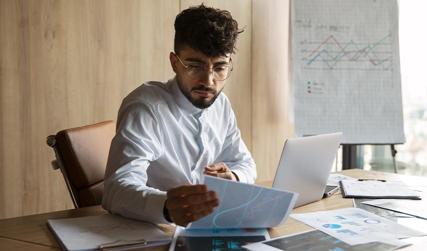 An alien entrepreneur reviewing investment trends and data charts for strategic EB5 decisionmaking.