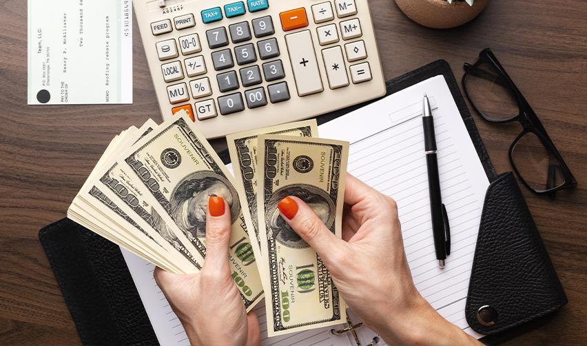 Close-up of a pair of hands counting cash, representing diverse funding methods for Indian students planning EB5 investments.
