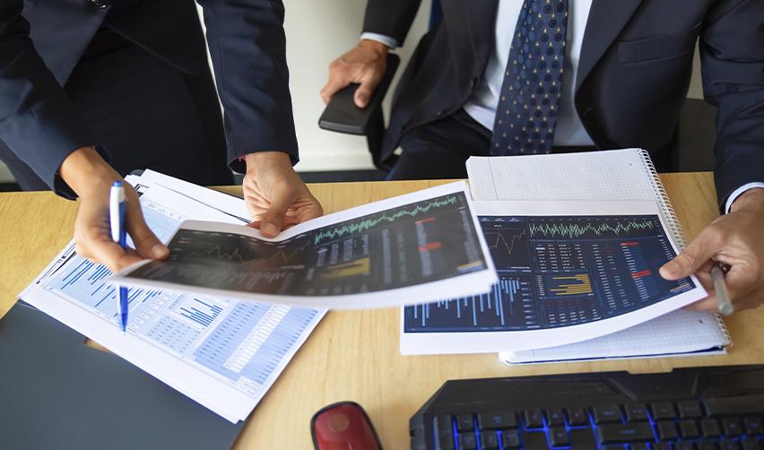 Two EB5 regional center industry professionals reviewing financial charts and documents, highlighting EB5 project evaluation and investment analysis.