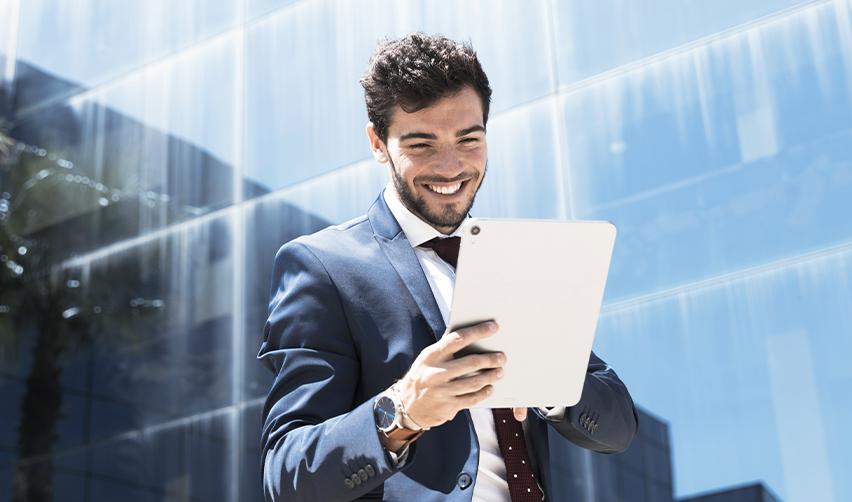 A smiling alien entrepreneur using a tablet for his EB5 visa details, symbolizing the process of getting a U.S. green card for New Zealand citizen.