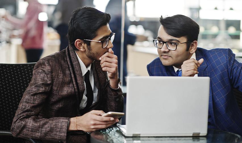 Two Indian F1 students analyzing EB5 investment strategies for Indian students.