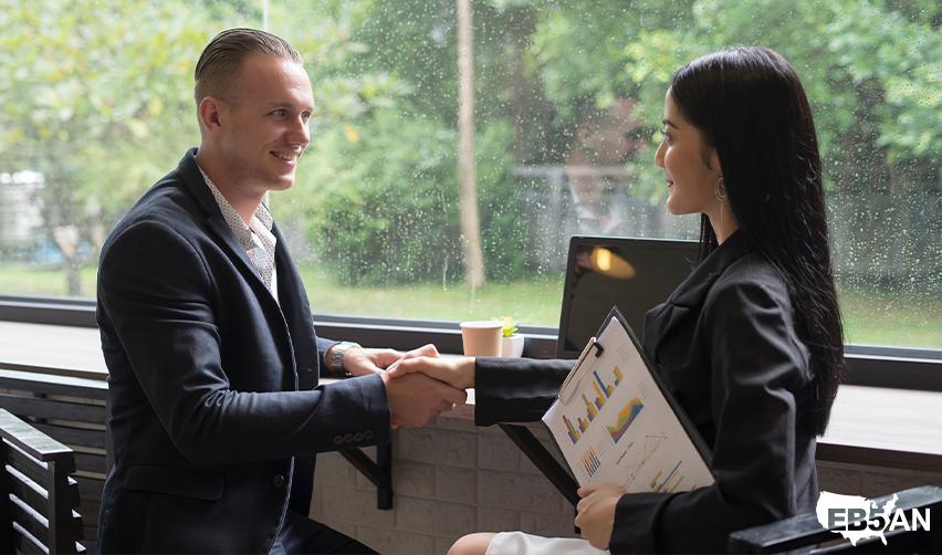 The EB5AN logo next to two professionals shaking hands during an EB5 consultation, symbolizing trust and guidance for immigrant investors seeking permanent residency in America.