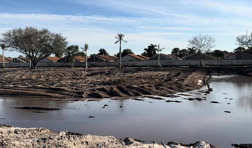 A body of water with houses in the background
