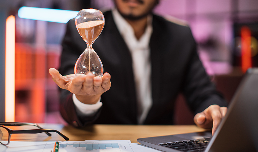 An EB5 investor holding an hourglass in his hand, symbolizing why duration matters in EB5 investments.