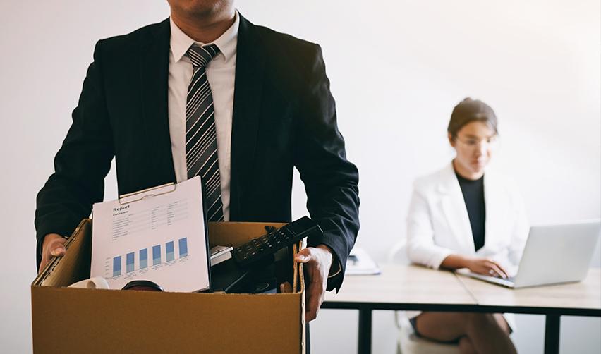 An Indian H1B employee packing up belongings after a layoff, symbolizing the instability faced by H1B visa holders in America and how an EB5 visa can help.