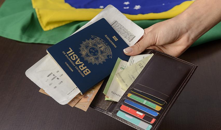 A Brazilian passport and wallet containing travel documents and cash, symbolizing the journey of green card applicants navigating the U.S. immigration process through U.S. Citizenship and Immigration Services.