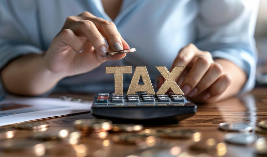 Hands using a calculator with a digital tax overlay, financial charts, and a laptop. Understanding U.S. tax obligations for EB5 investors, including K1 forms and taxable income.