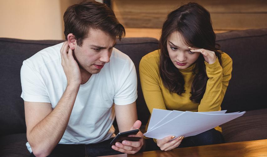 Worried family members reviewing immigration documents after an EB5 application denial, wondering can another family member apply for EB5 if one application is denied.