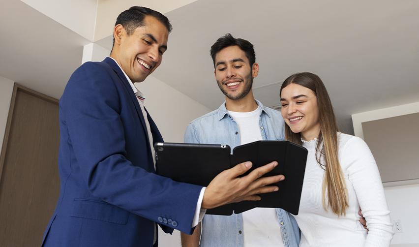 Smiling regional center representative presenting options to a couple, highlighting the role of EB5AN in guiding investors through the EB5 process and offering peace of mind in immigration planning.