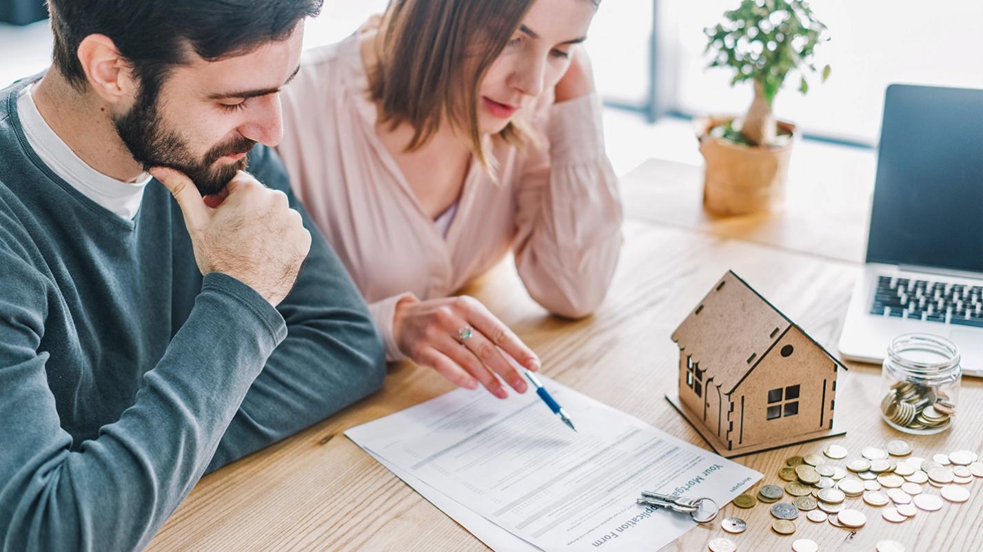 A couple reviewing rental agreements and financial considerations before renting or buying a home in Puerto Rico.