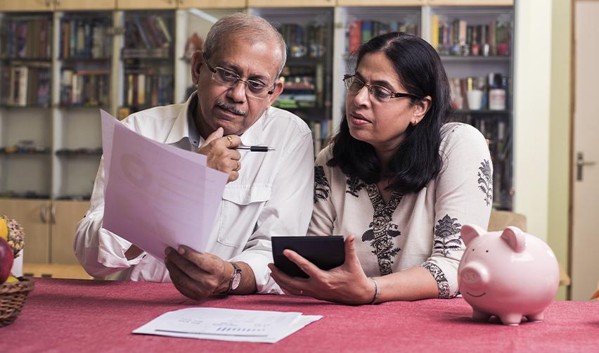 Older Indian couple evaluating Eb5 investment opportunities at home, discussing timing strategies to secure US Green Card benefits.