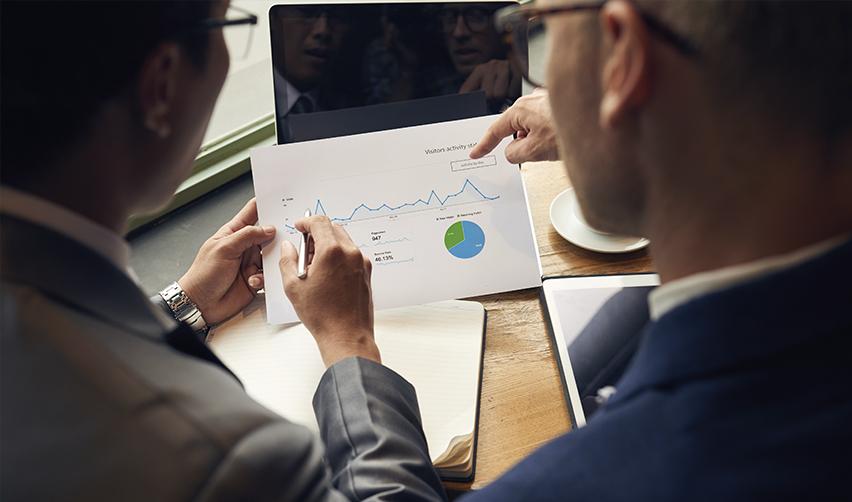 Business professionals analyzing project sustainability metrics for EB5 investments, highlighting financial viability and market trends.