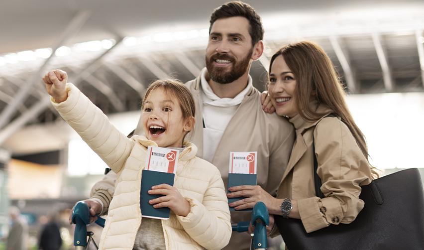 Happy family with passports at an airport terminal, symbolizing EB5 investors preparing for international travel after receiving a Green Card.