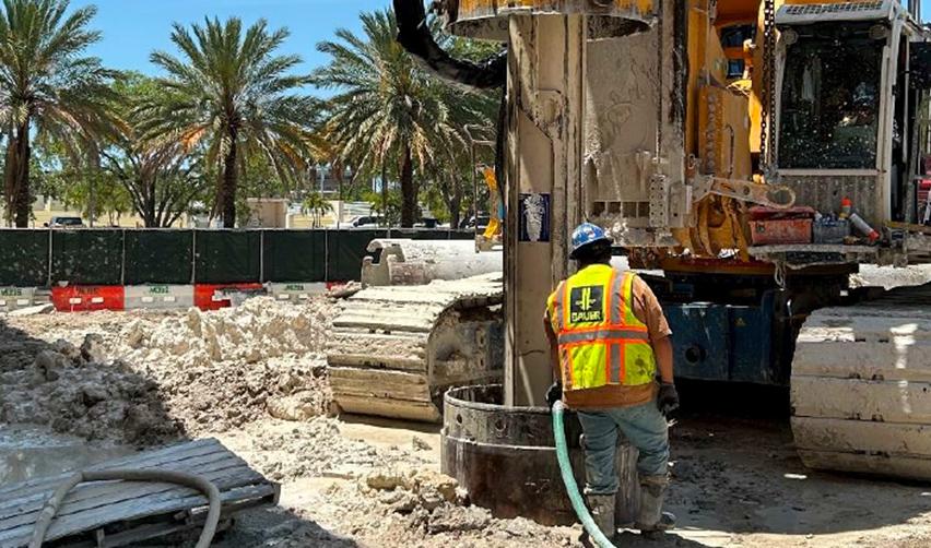 A construction worker using a hose to pump water