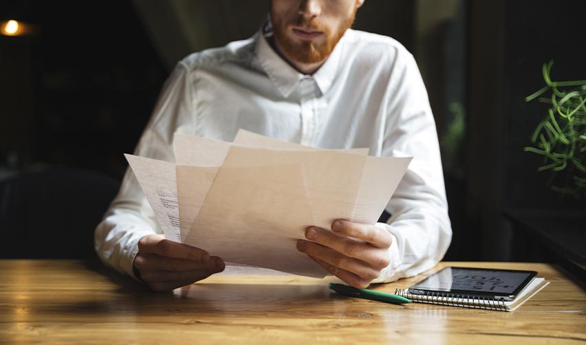 A man reviews EB5 investment documents at a desk, symbolizing investor due diligence and petition preparation.