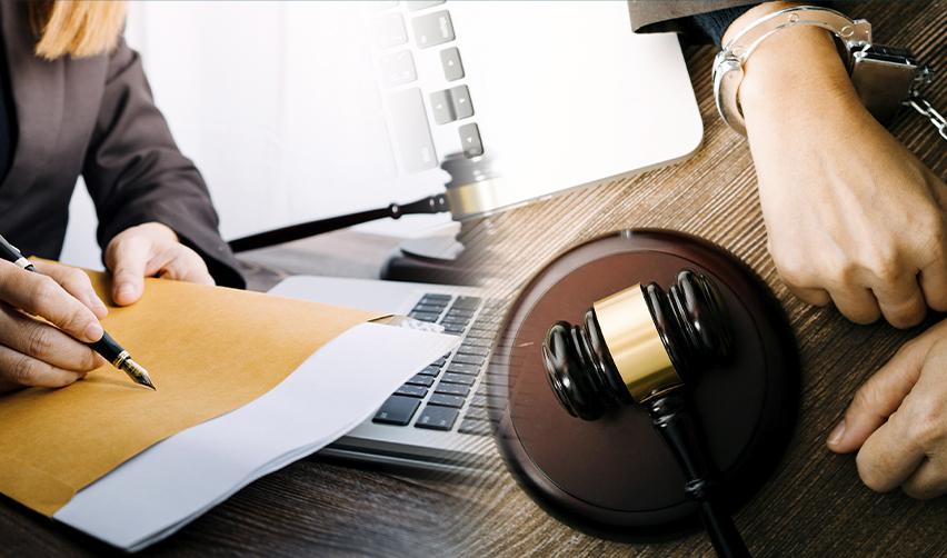 A lawyer signing documents beside a gavel and handcuffed hands, representing the legal consequences visa holders may face for criminal offenses, including charges like domestic violence.