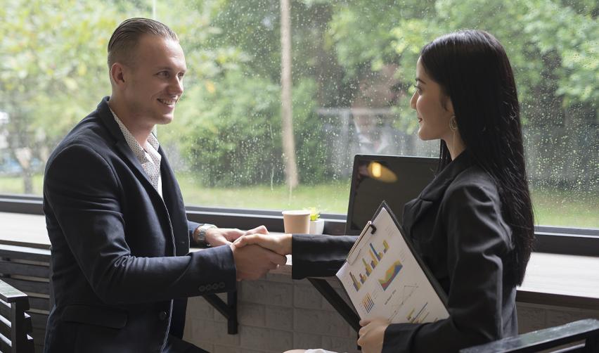 EB5 investor confidently shaking hands with a regional center principal, symbolizing partnership and trust.
