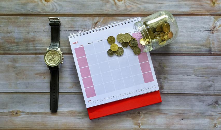 A watch, scattered coins, and a calendar, symbolizing EB5 investment timelines and the sustainment period requirement.