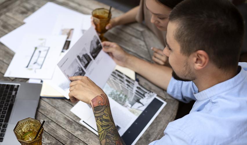 A couple reviewing architectural plans and investment documents, symbolizing EB5 investors evaluating rural and urban project options for set aside visas.