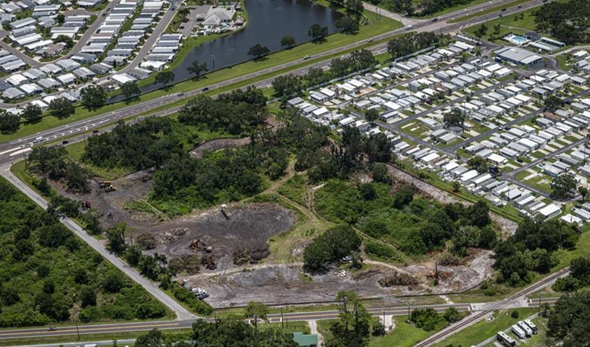 Aerial view of the Terra Ceia urban EB5 project site in Palmetto, Florida, showing cleared land, surrounding greenery, and nearby residential community.
