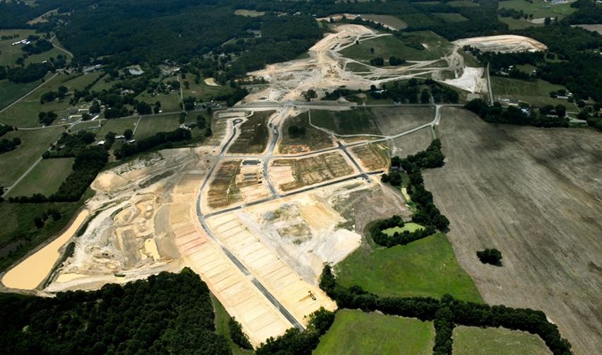 Wide aerial shot of Rocky River EB5 rural development near Charlotte, featuring completed road layouts, prepared residential lots, and large-scale earthworks.