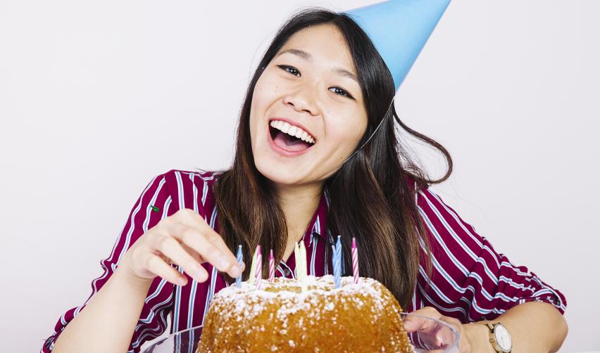 Smiling teenage girl celebrating her birthday with a cake, representing EB5 families planning ahead to avoid the child age-out risk before turning 21