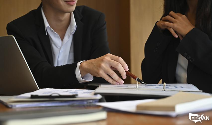 Two professionals reviewing documents during a meeting, depicting EB5 investors consulting immigration attorneys for multi-visa strategies.