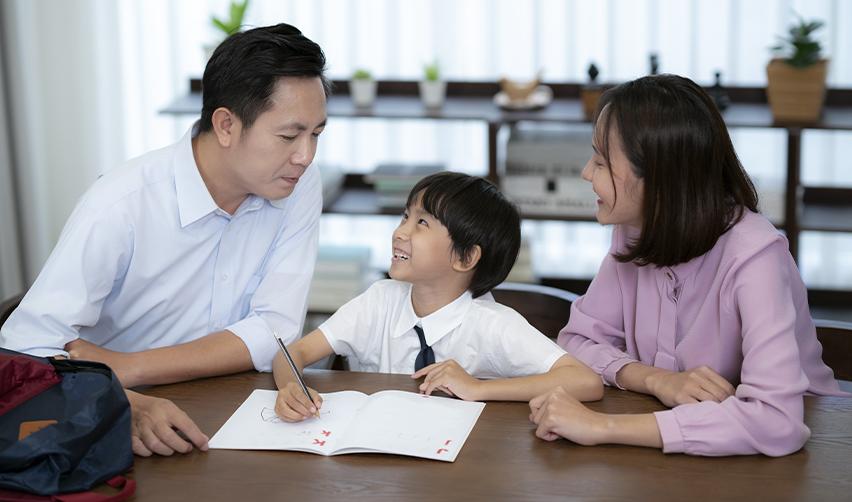 Parents supporting their young son with schoolwork at home, illustrating EB5 families planning early for their children’s U.S. education journey.